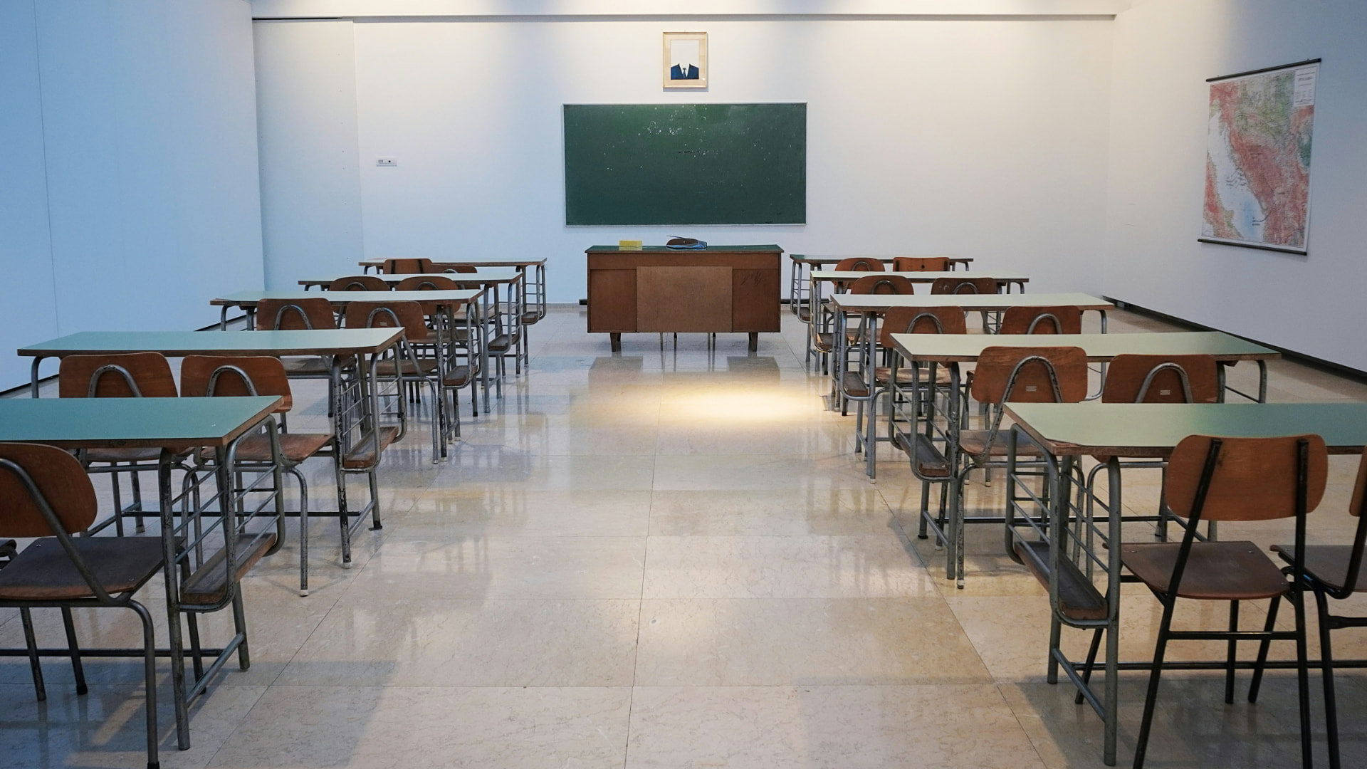 A tidy classroom set up with desks facing the board, ready for a small group class