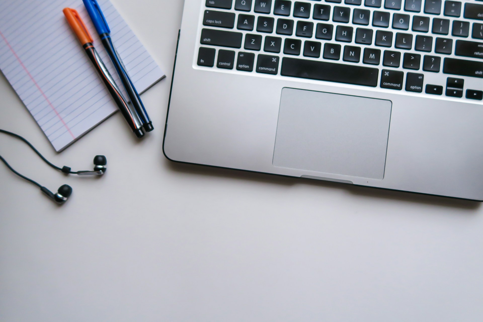 A laptop and ruled notepaper set up for online learning
