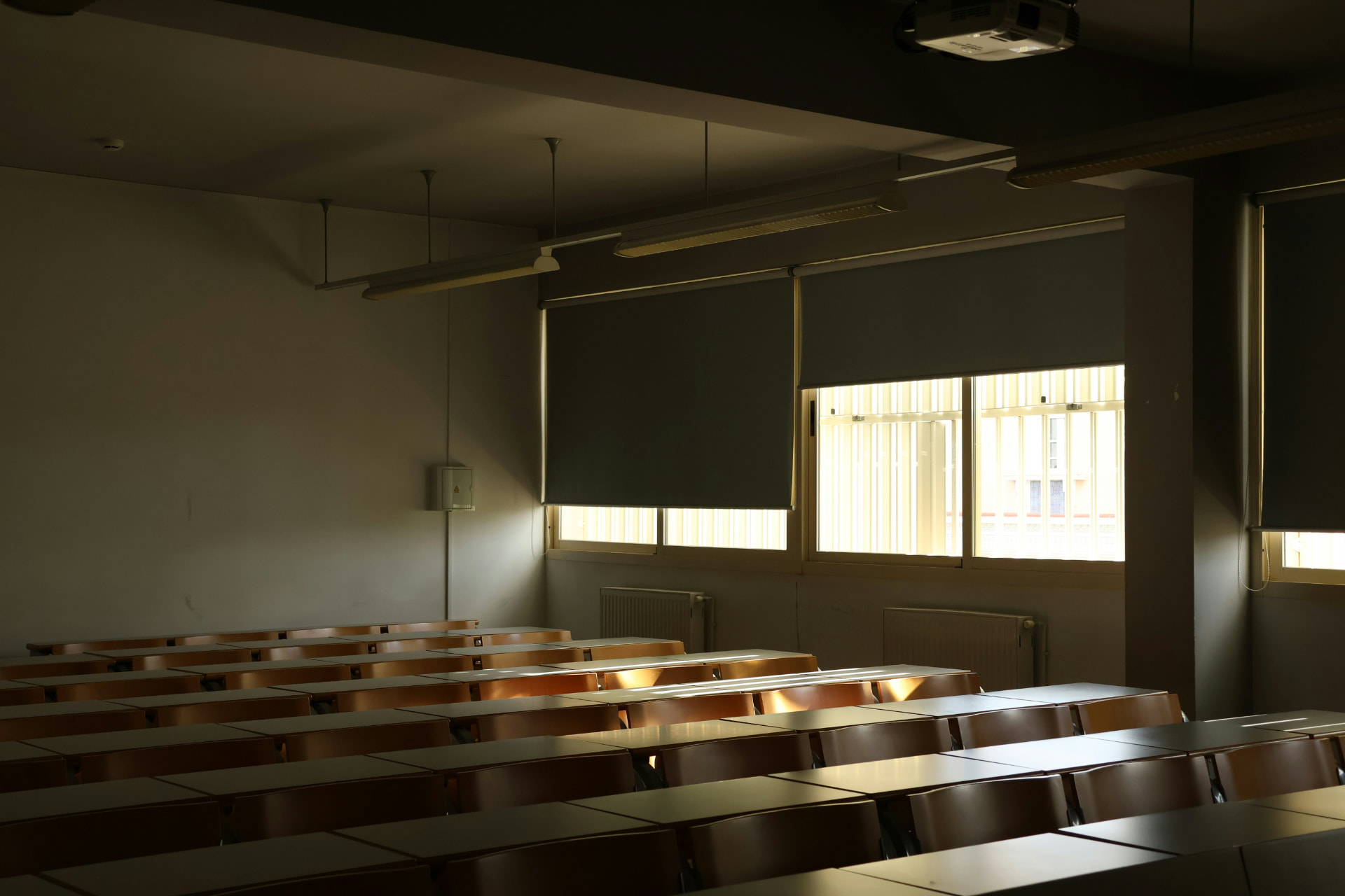 Late afternoon light across rows of desks in a quiet lecture room